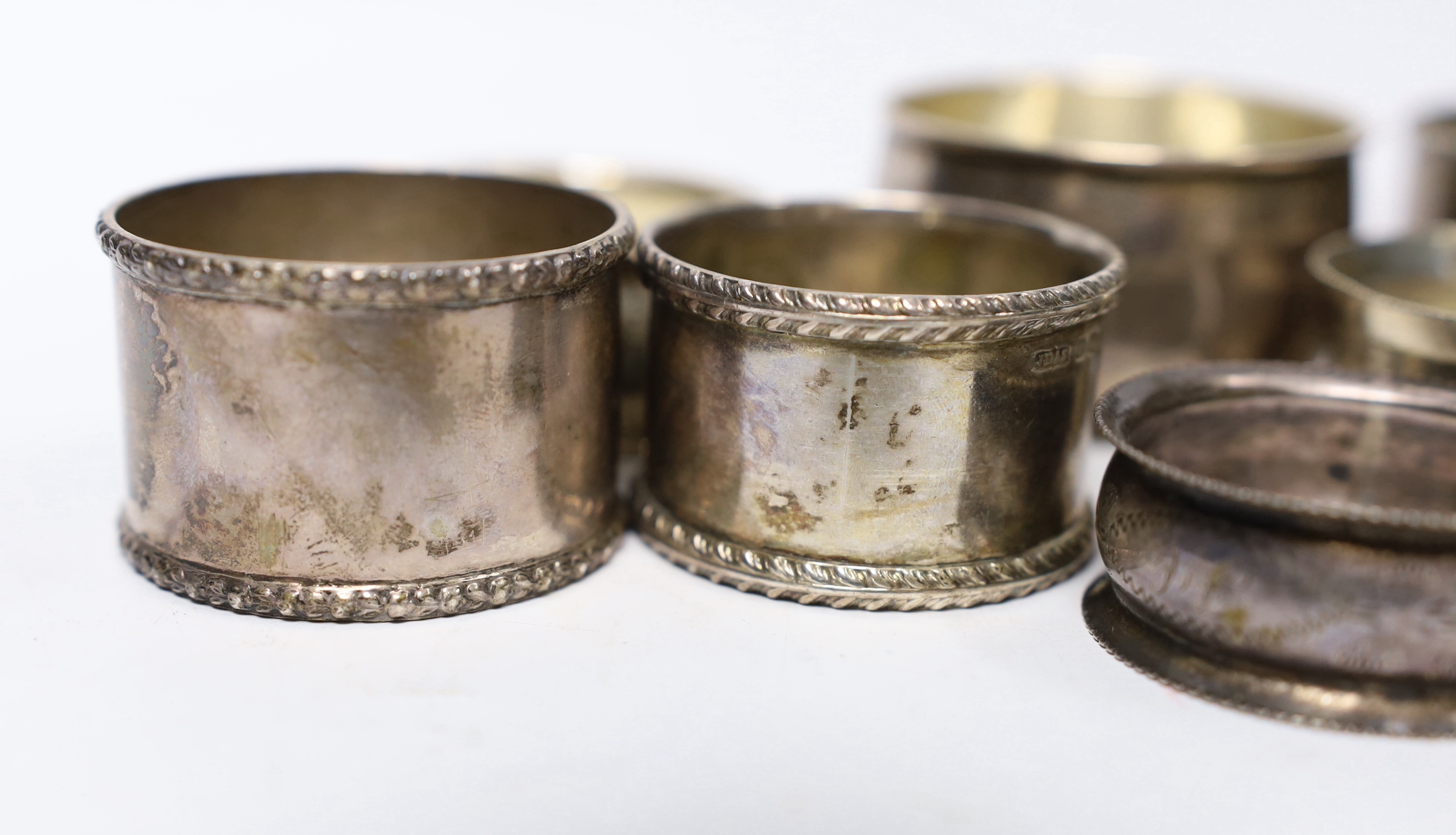 Seven assorted silver napkin rings and a small silver bowl